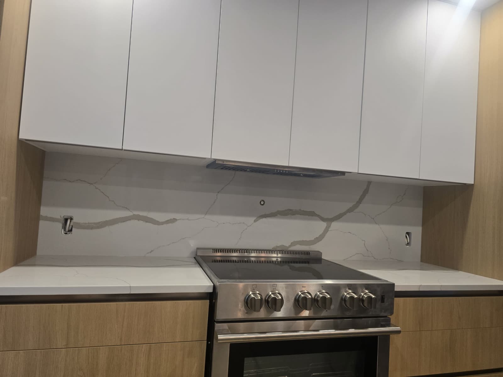 Dosseret pleine hauteur en quartz Calacatta derrière cuisinière